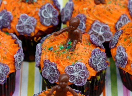 Rosewater Red Velvet Cupcakes with Orange Vermouth Frosting, King Cake Babies, and Glitter, by Gertie